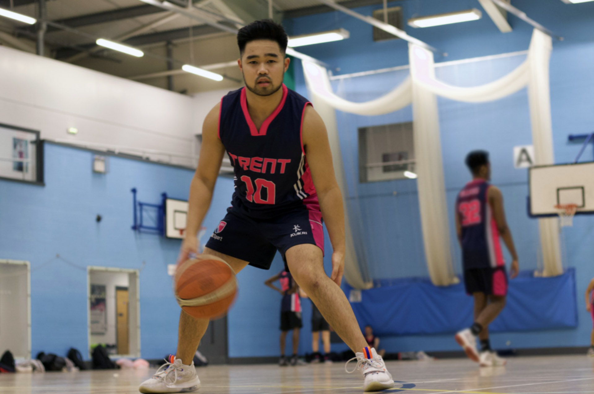 Sean plays basketball on a court at NTU