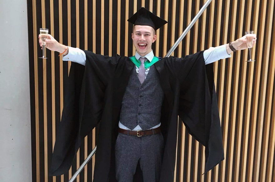 Dominic Chandler wearing his cap and gown at graduation day