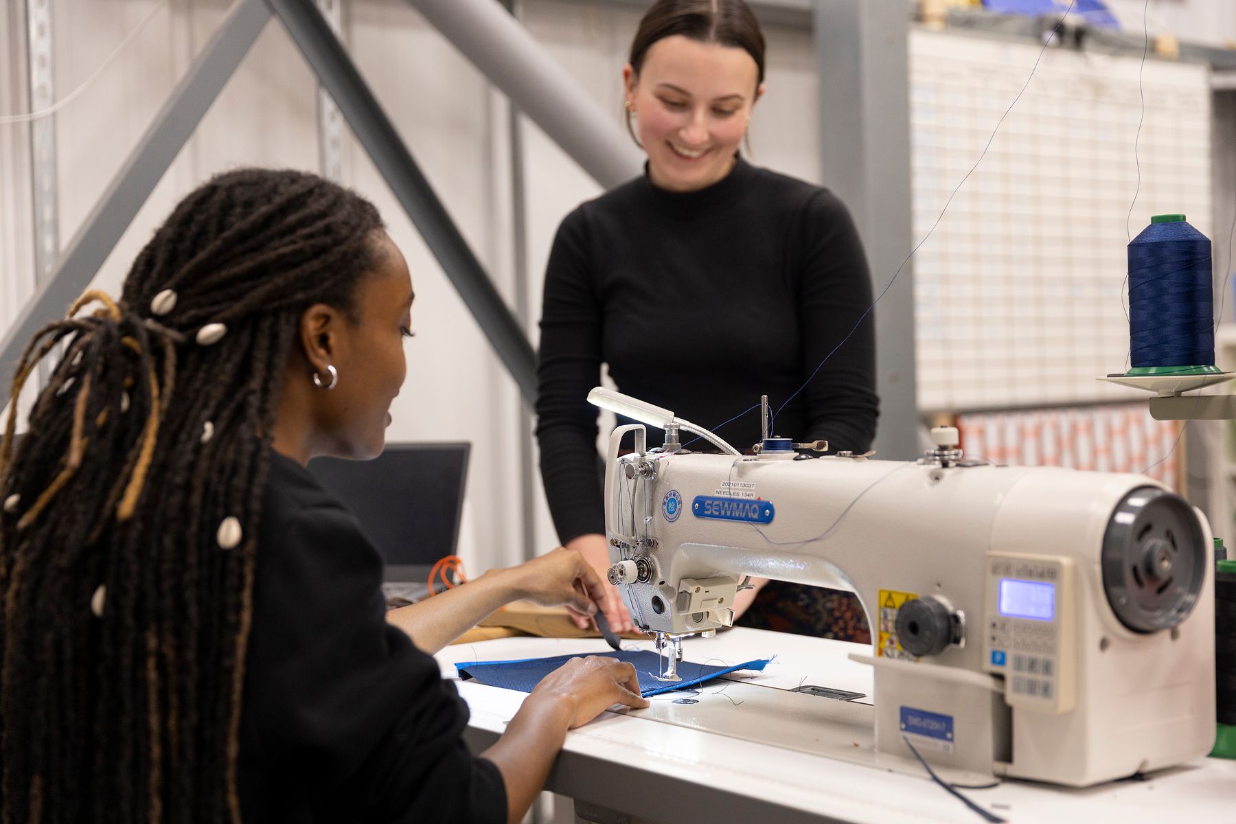 Two people by a sewing machine