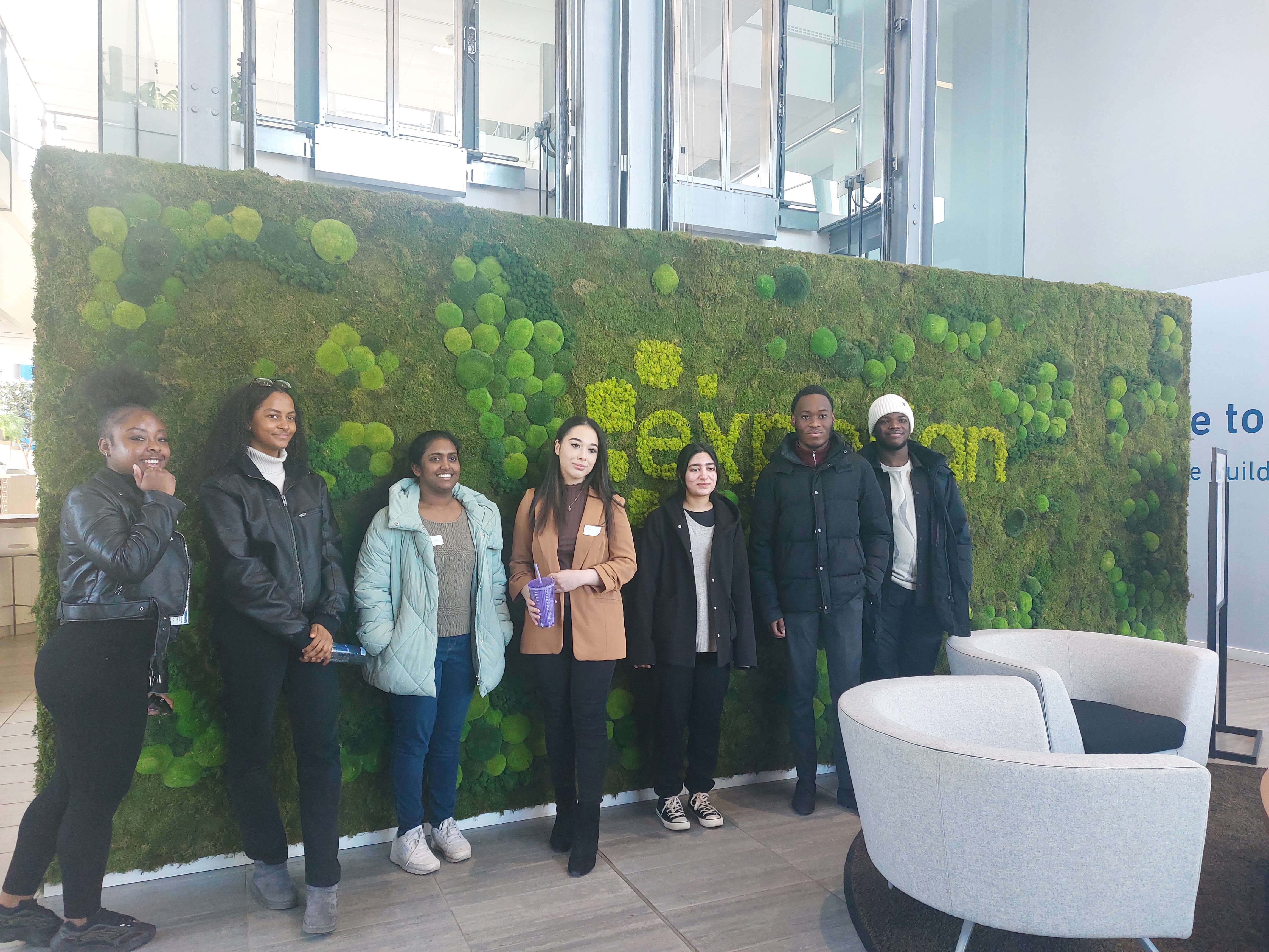 Students standing in front of Experian sign