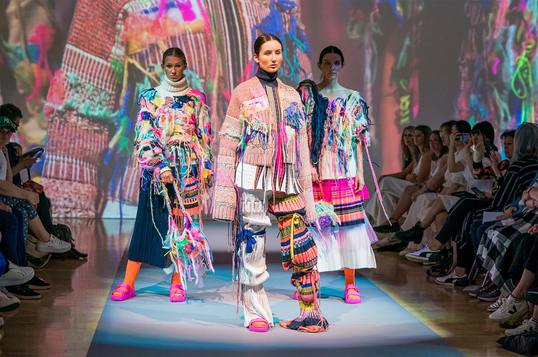 Models posing in knitwear designs at graduate fashion week