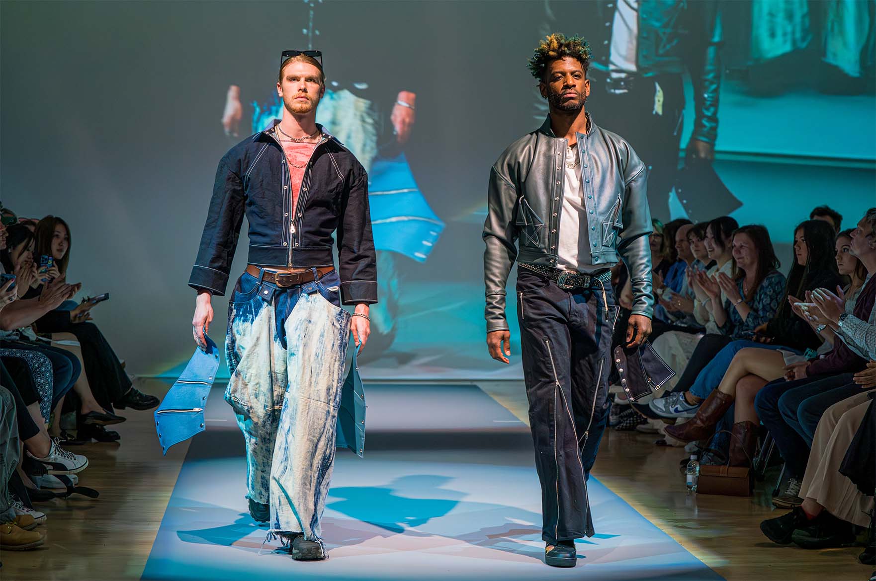 Models posing in fashion design student work at graduate fashion week
