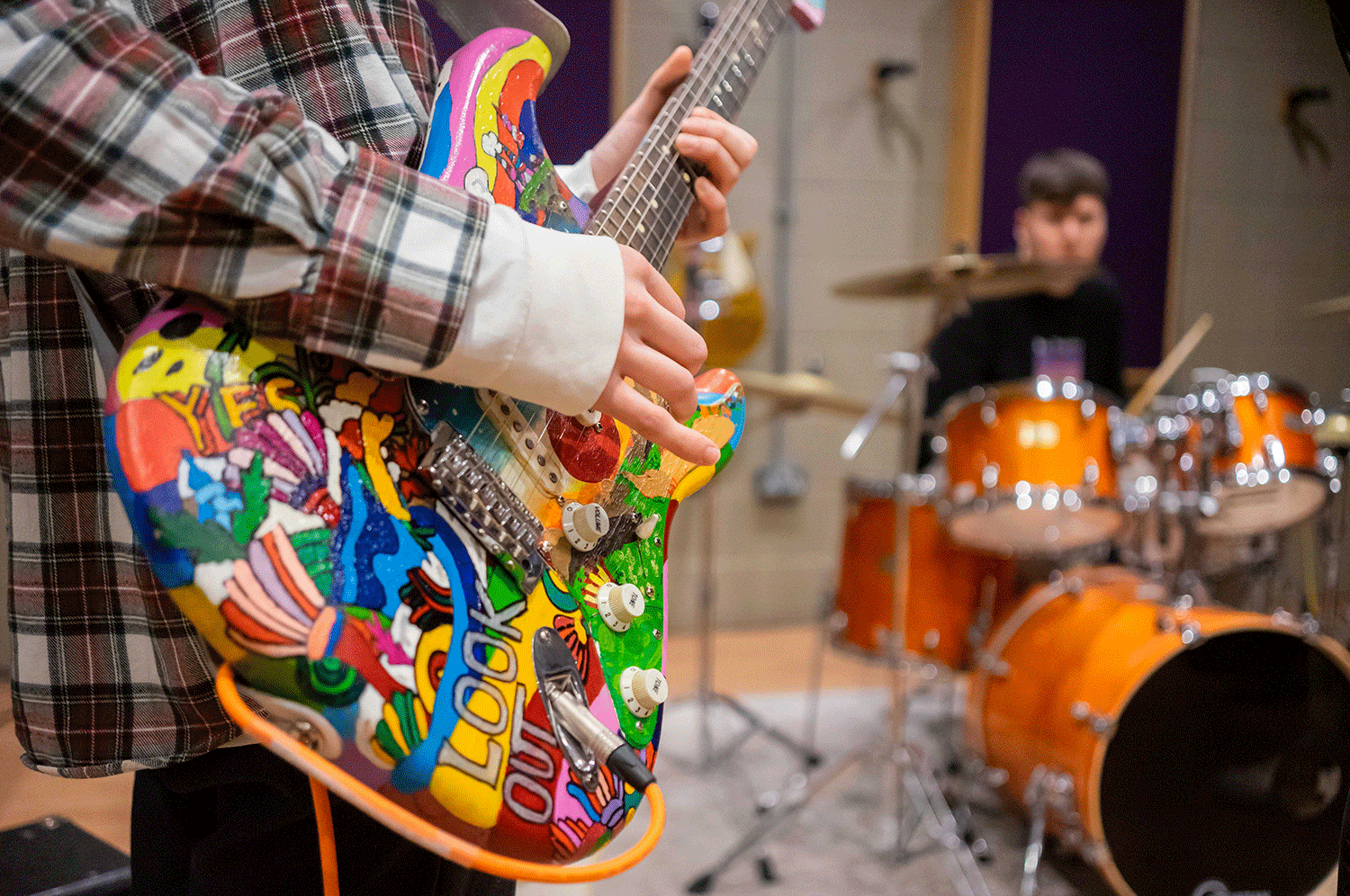 A guitarist and a drummer practising