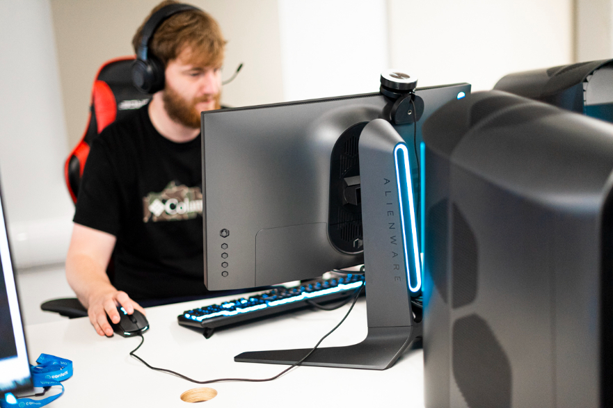 Student using a gaming pc using a gaming mouse and sat in a gaming chair