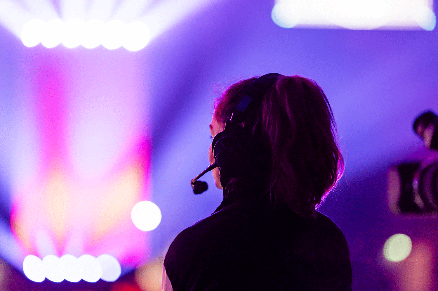 An event manager looks on at the performance with head gear on