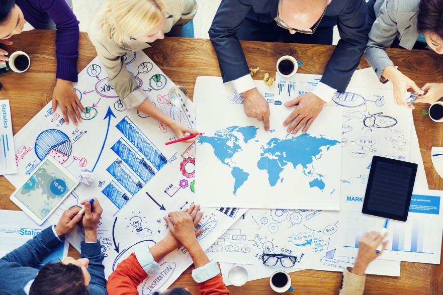 People working on global problem around desk