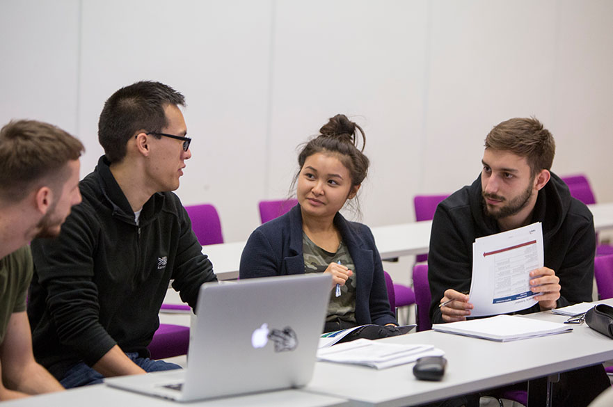 Students sat around a laptop