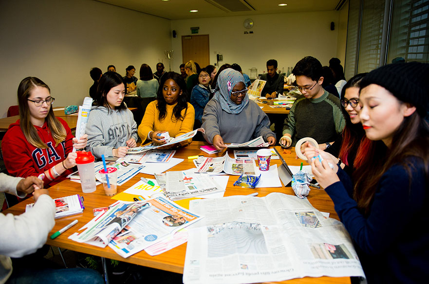 Students around a table doing papercraft