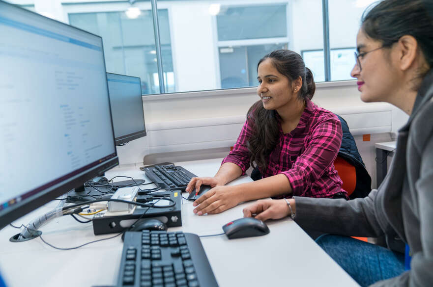 Artificial Intelligence students sitting at laptop