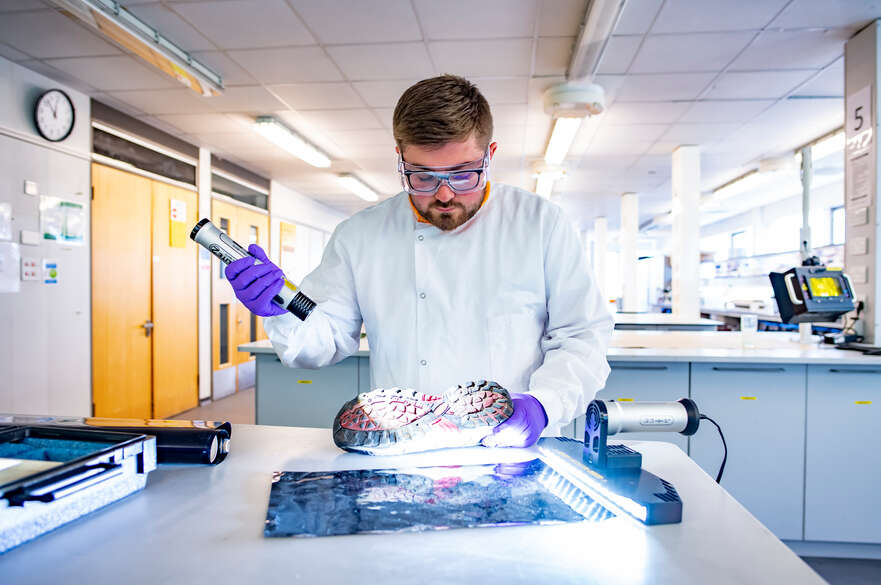 Forensic Science student in the lab analysing footprints from a shoe