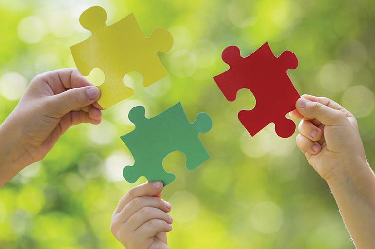 £ hands holding jigsaw puzzle pieces