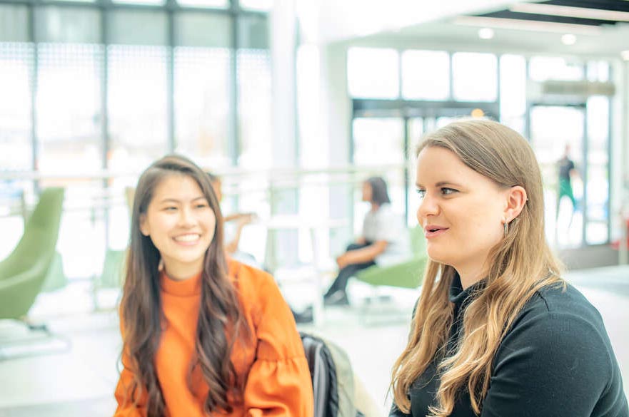 Two students in the reception of the Health and Allied Professions Centre at Clifton Campus
