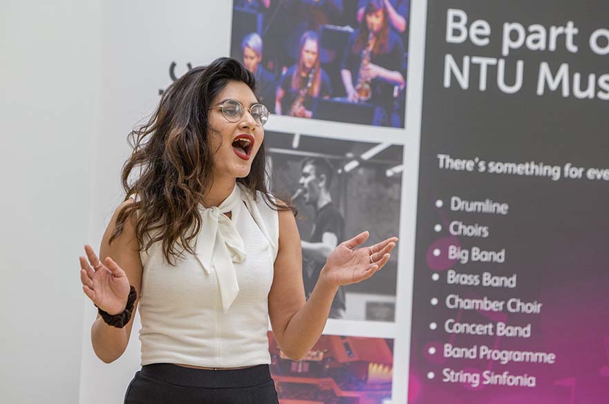 A woman wearing glasses singing