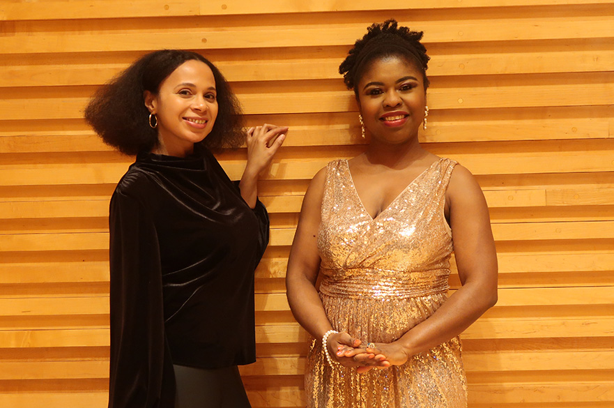 Two women (Rebeca Omordia and Omo Bello) stood together smiling.
