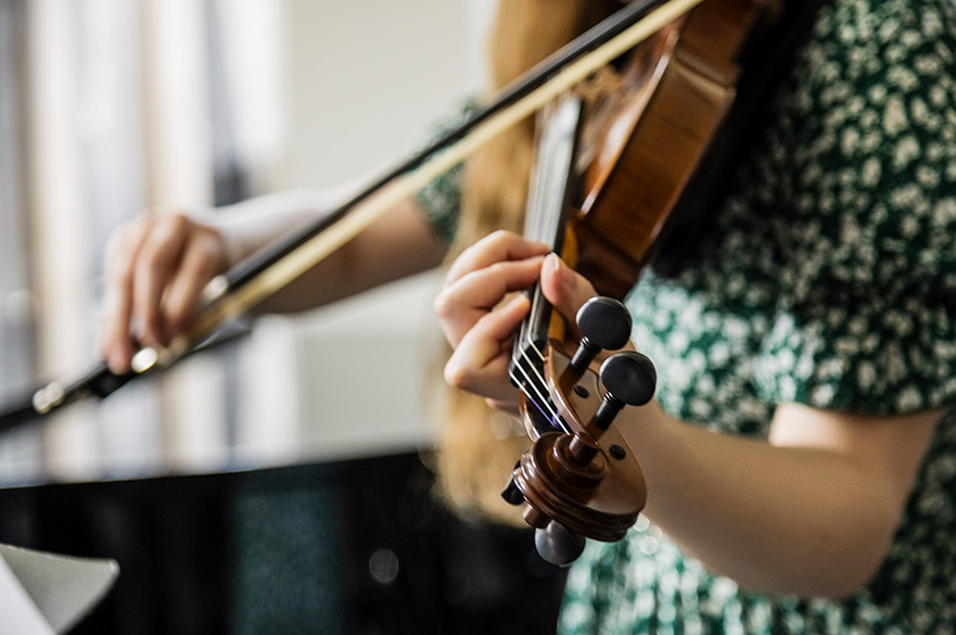 A close up of a girl playing the violin.