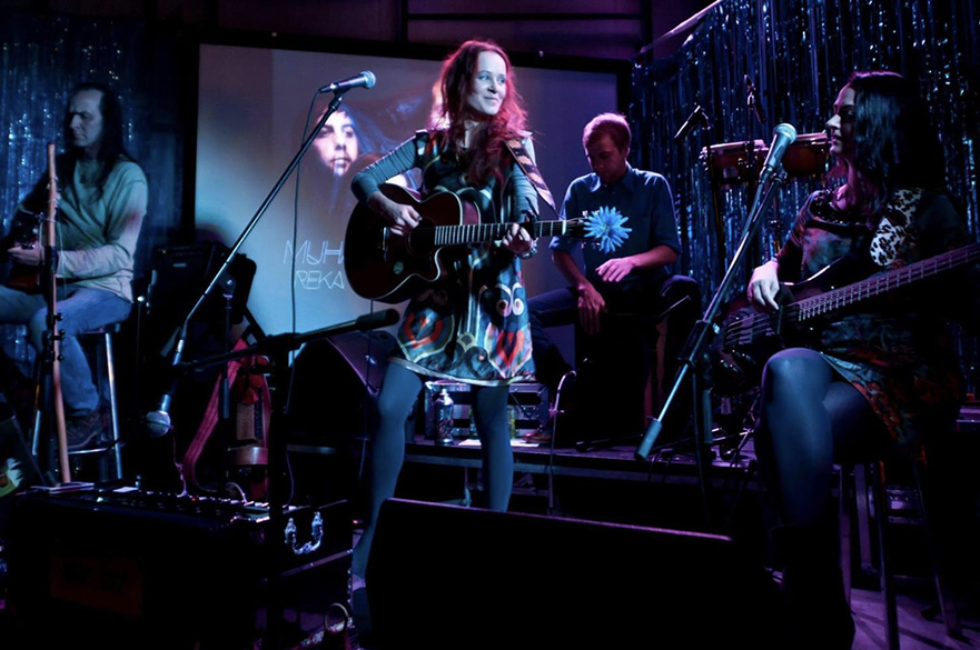 Four musicians performing on stage.