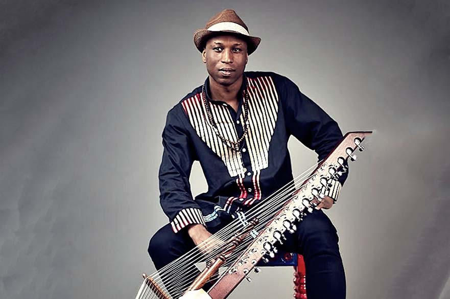 Kadialy Kouyate sat holding a kora.