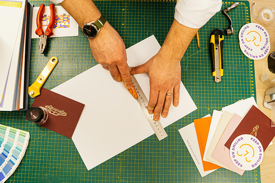 A pair of hands making zine crafts.