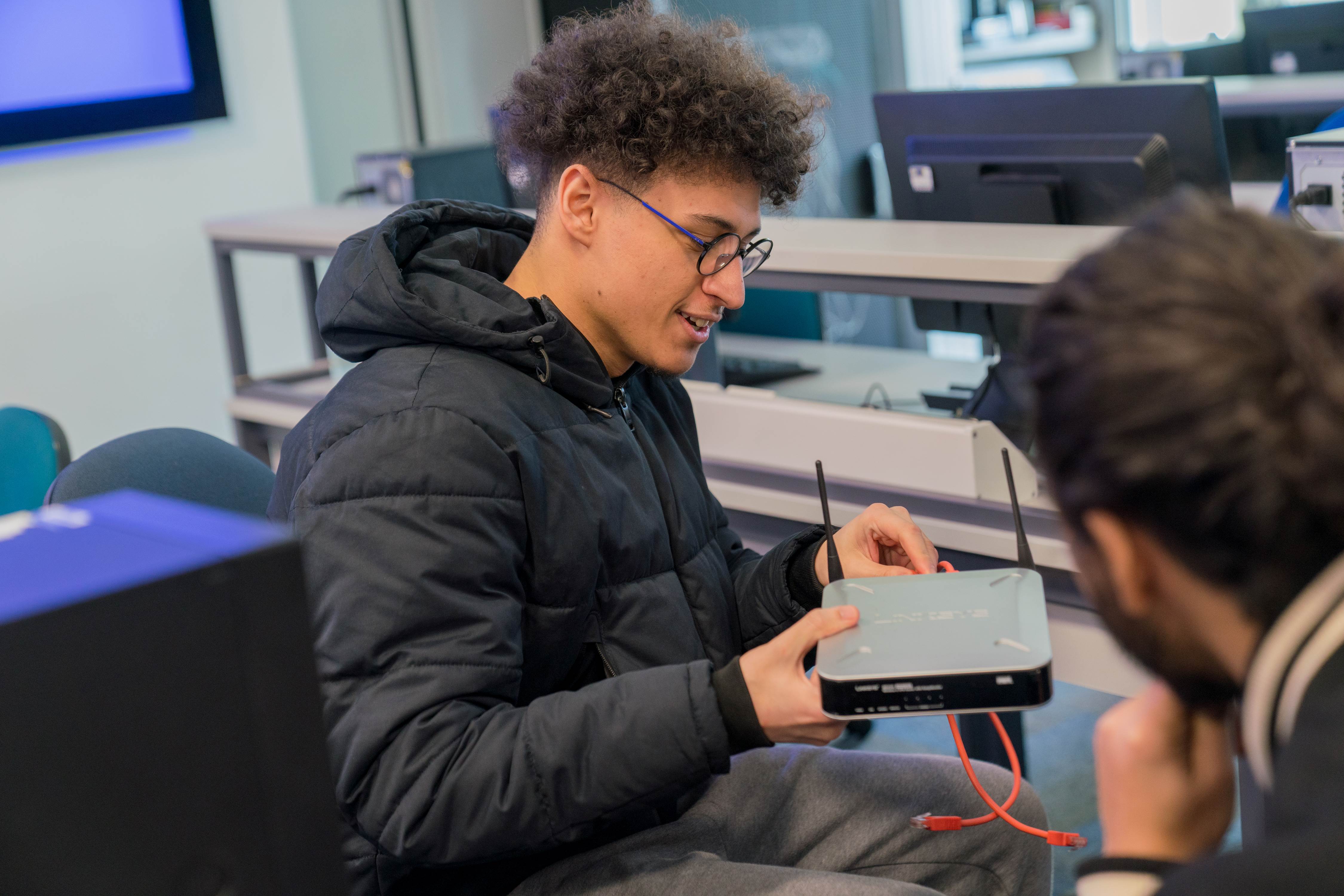 student holding internet modem
