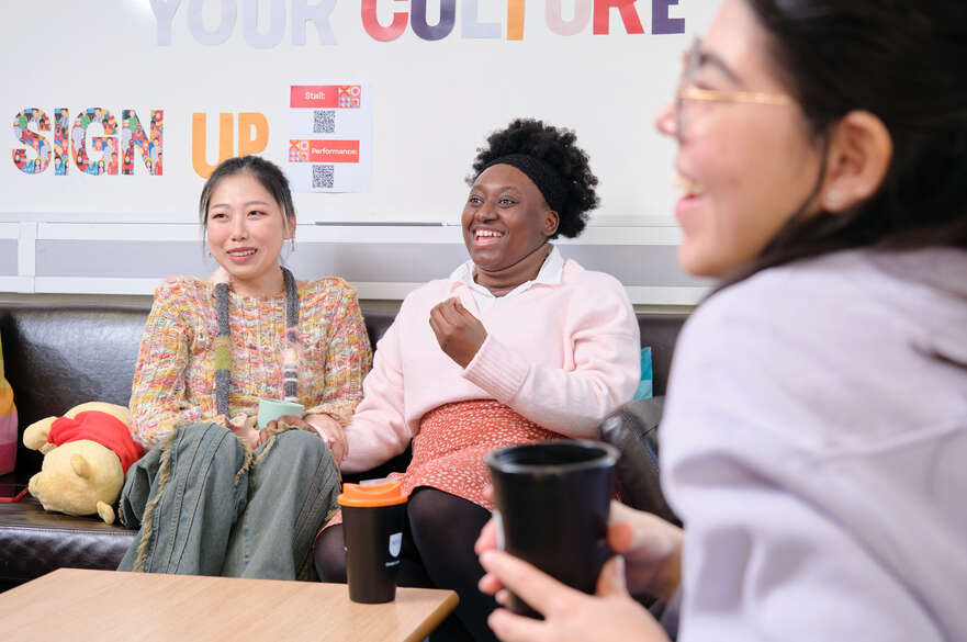 diverse group of students chatting and laughing in clifton global lounge