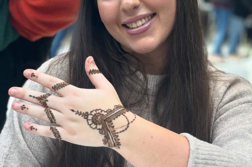 female student showing henna artwork on her hand