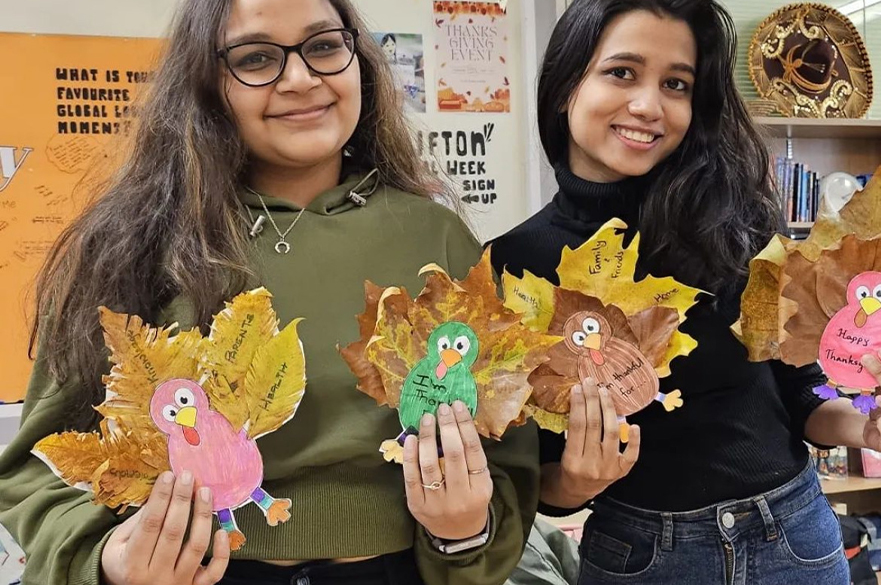 students holding thanksgiving craft at global lounge