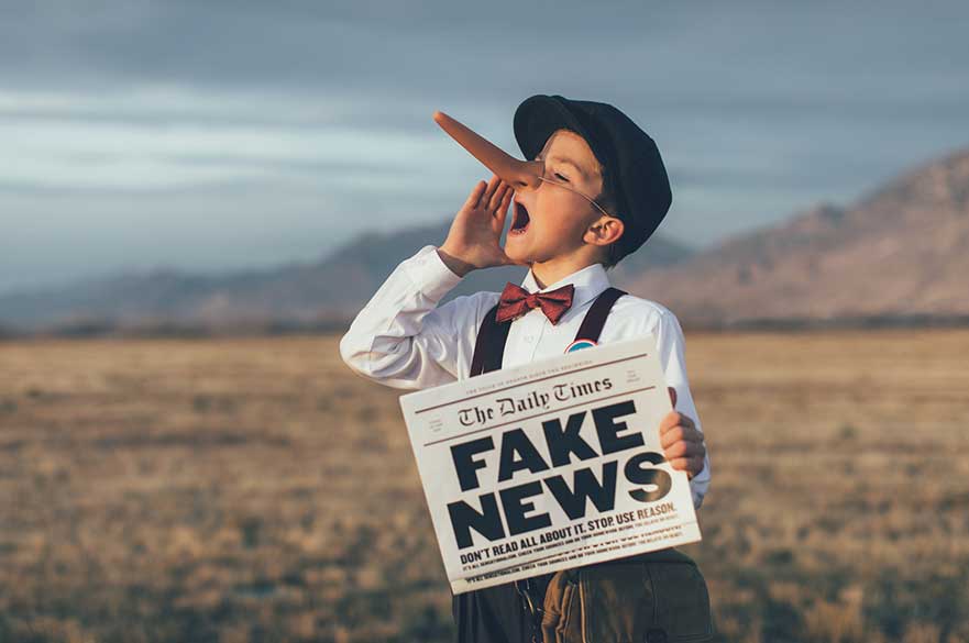 Boy with fake news newspaper