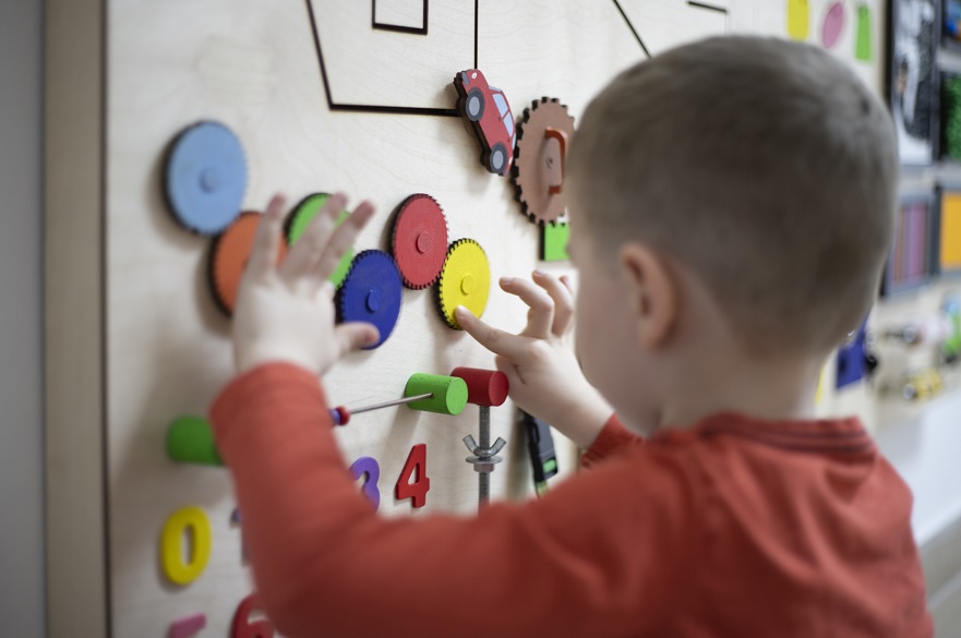 Child playing with a sensory board