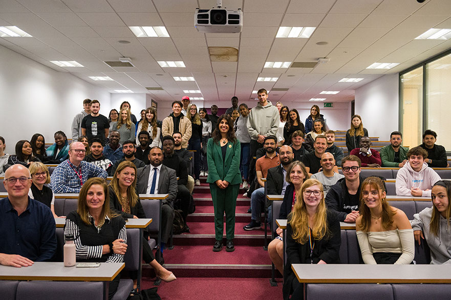 Lubna stood in the lecture theatre with attendees around her