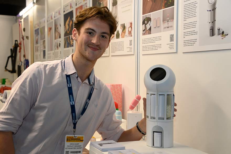 Student posing next to project