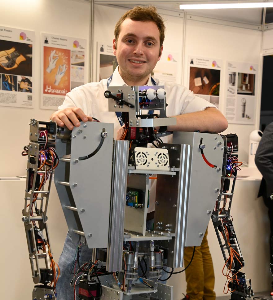 Student posing next to project