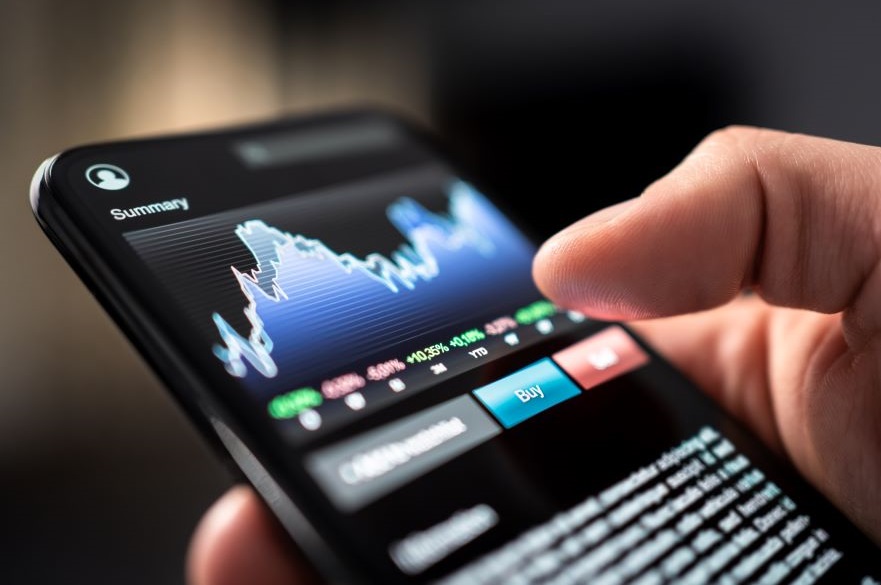 Stock market trade with phone. Finance analysis graph and chart in crypto currency, forex, index fund or etf mobile app. Stockmarket broker and investor holding smartphone in hand. Risk investing