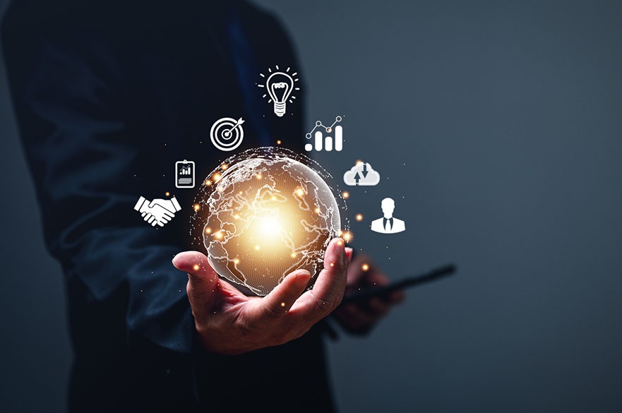 Hand holding a glowing globe with business and computing icons around it