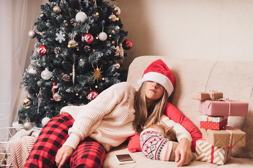 Woman lying on the sofa in a santa hat
