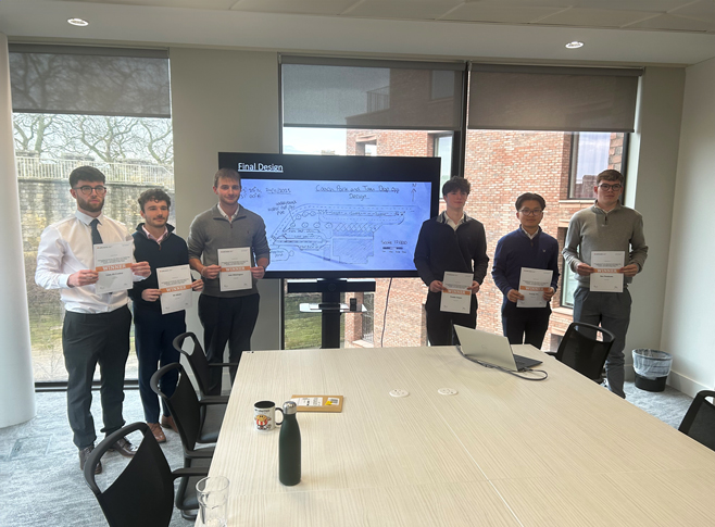 Civil Engineering students stood around a conference table holding up their aweards.