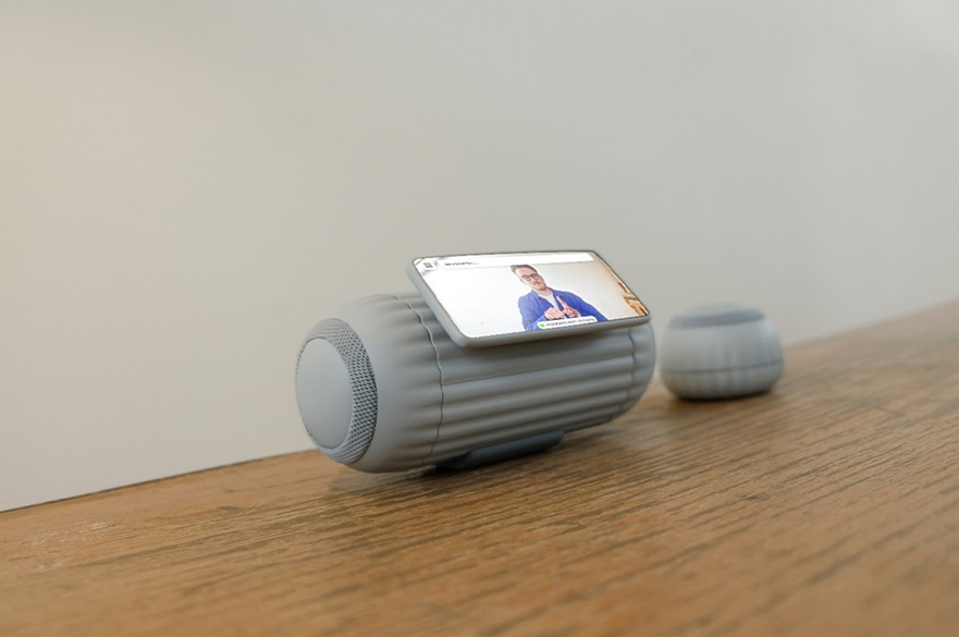 Render of a grey speaker with a screen attached to it.