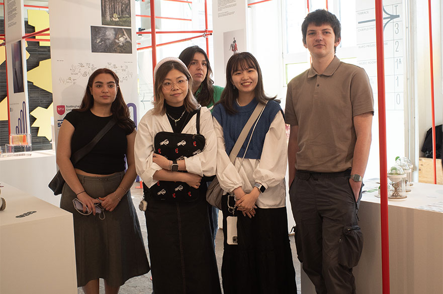 NTU students posing for a picture next to their innovative projects at the Simplexity in Design Exhibition 2024