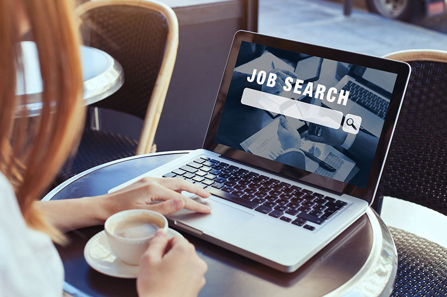 Woman sat at a computer with a job search screen