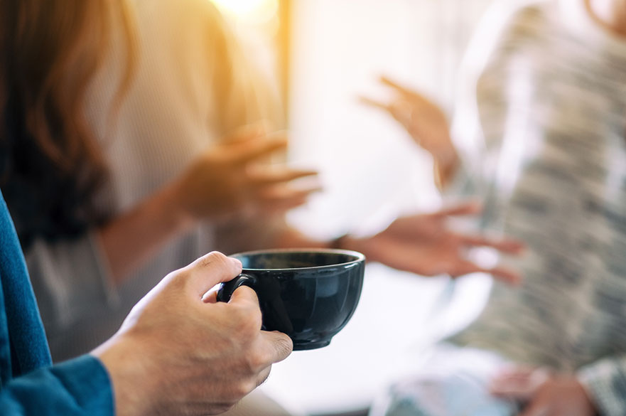 Women's hands holding a cup of coffee blurred background