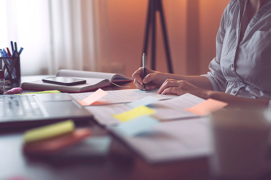 Woman sitting at a desk with lots of paperwork