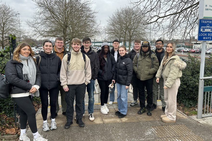 A group of NTU students standing at the tram stop for the NET depot in Nottingham