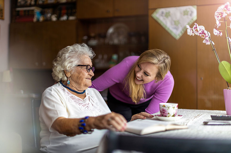Young woman spending time with an elderly lady at her home