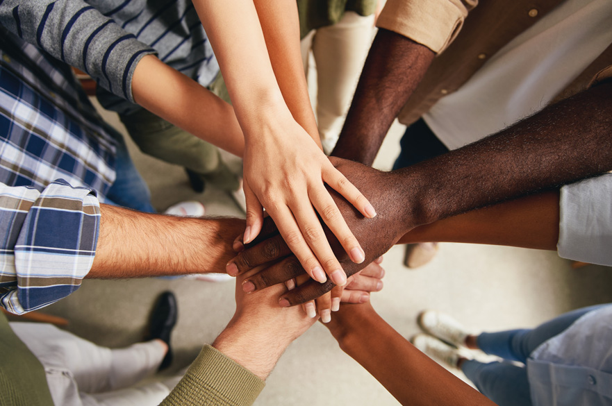 A range of hands placed on top of one another.