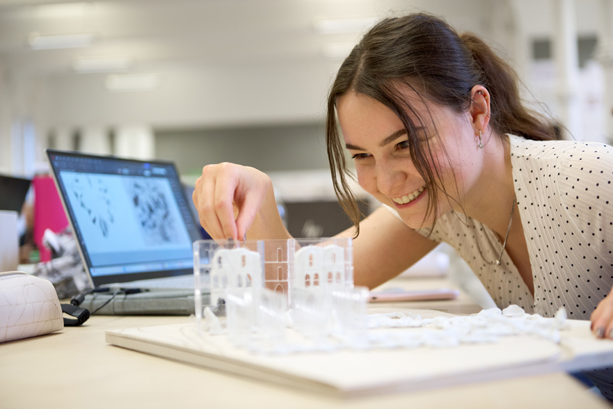 Architecture students smiling and working on her project.