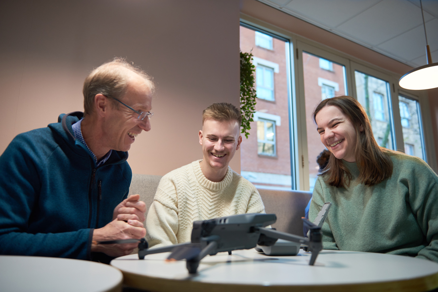 Academic showing a drone to students