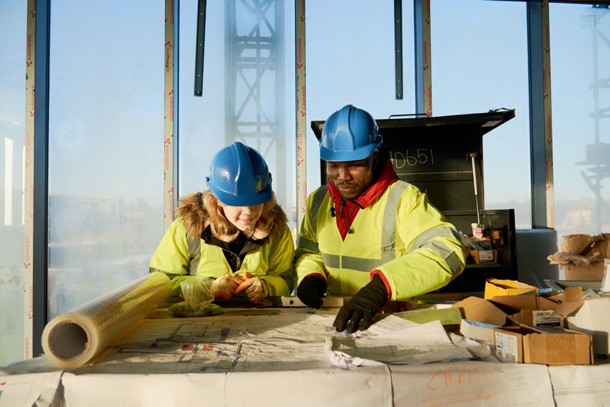 Student in a construction site looking at building plans