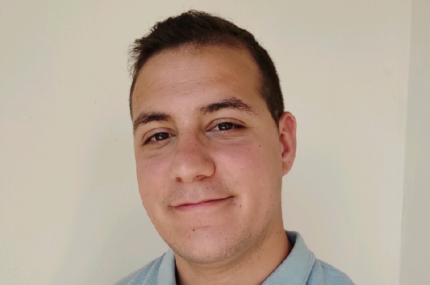 Man in blue shirt smiling at camera