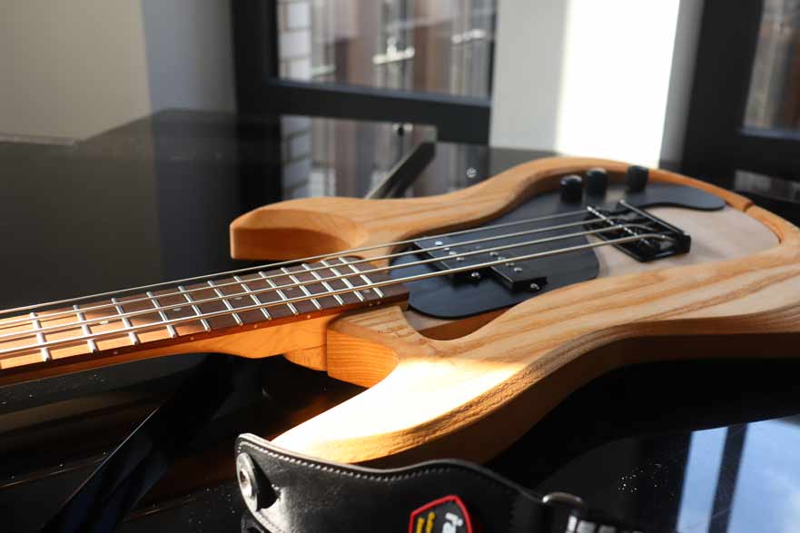 An electric guitar laying on top of a piano