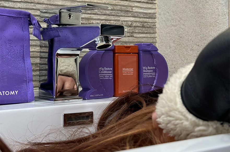 Someone washing a wig using Carlma's product.