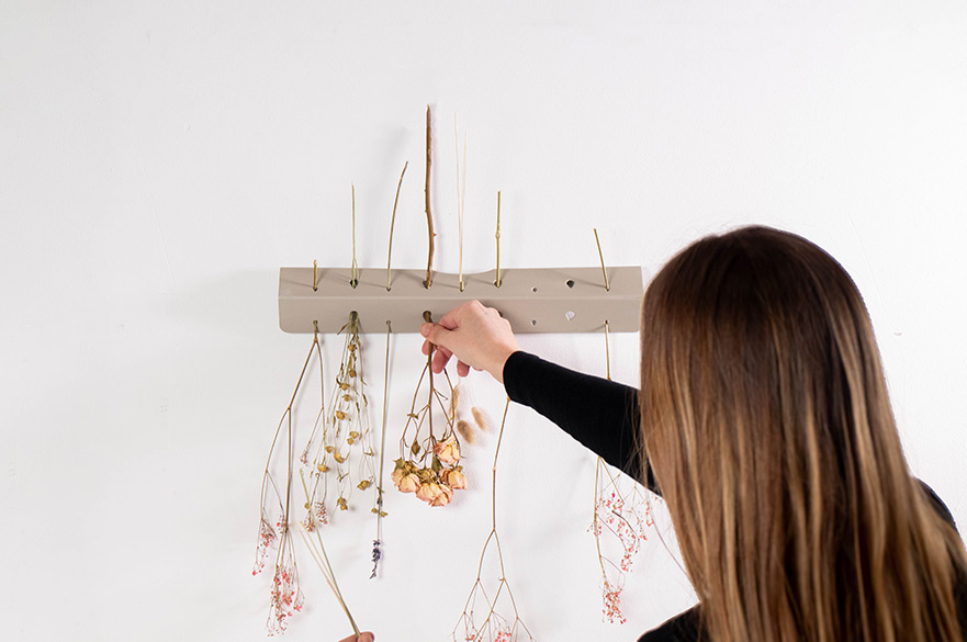 Woman placing flowers on a wooden project